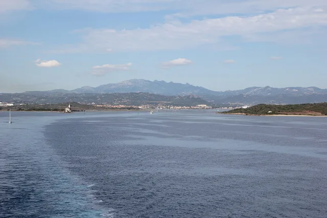 Il golfo di Olbia dal mare, il vecchio faro, la citta' sullo sfondo e i monti