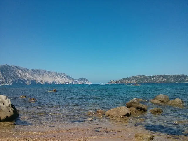 Il mare tra gli scogli di Punta Molara con Tavolara e Molara all'orizzonte