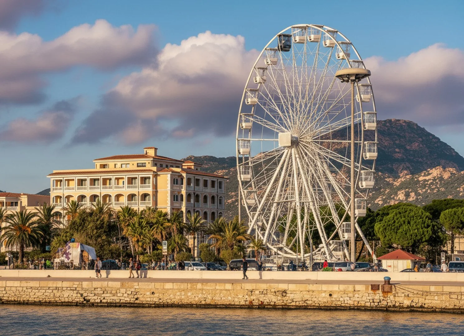 Il lungomare di Olbia al tramonto, con la ruota panoramica e i palazzi affacciati sul porto