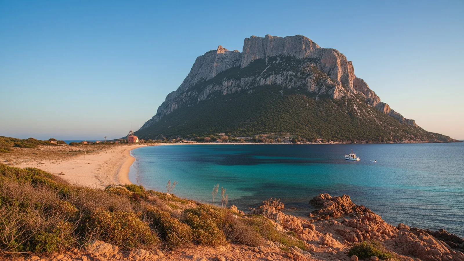 L'isola di Tavolara che emerge dal mare vista dalla costa, con la spiaggia in primo piano